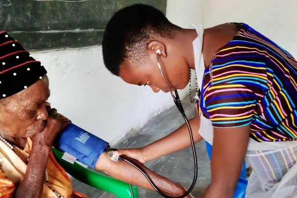 A nurse checking an elderly patient's blood pressure