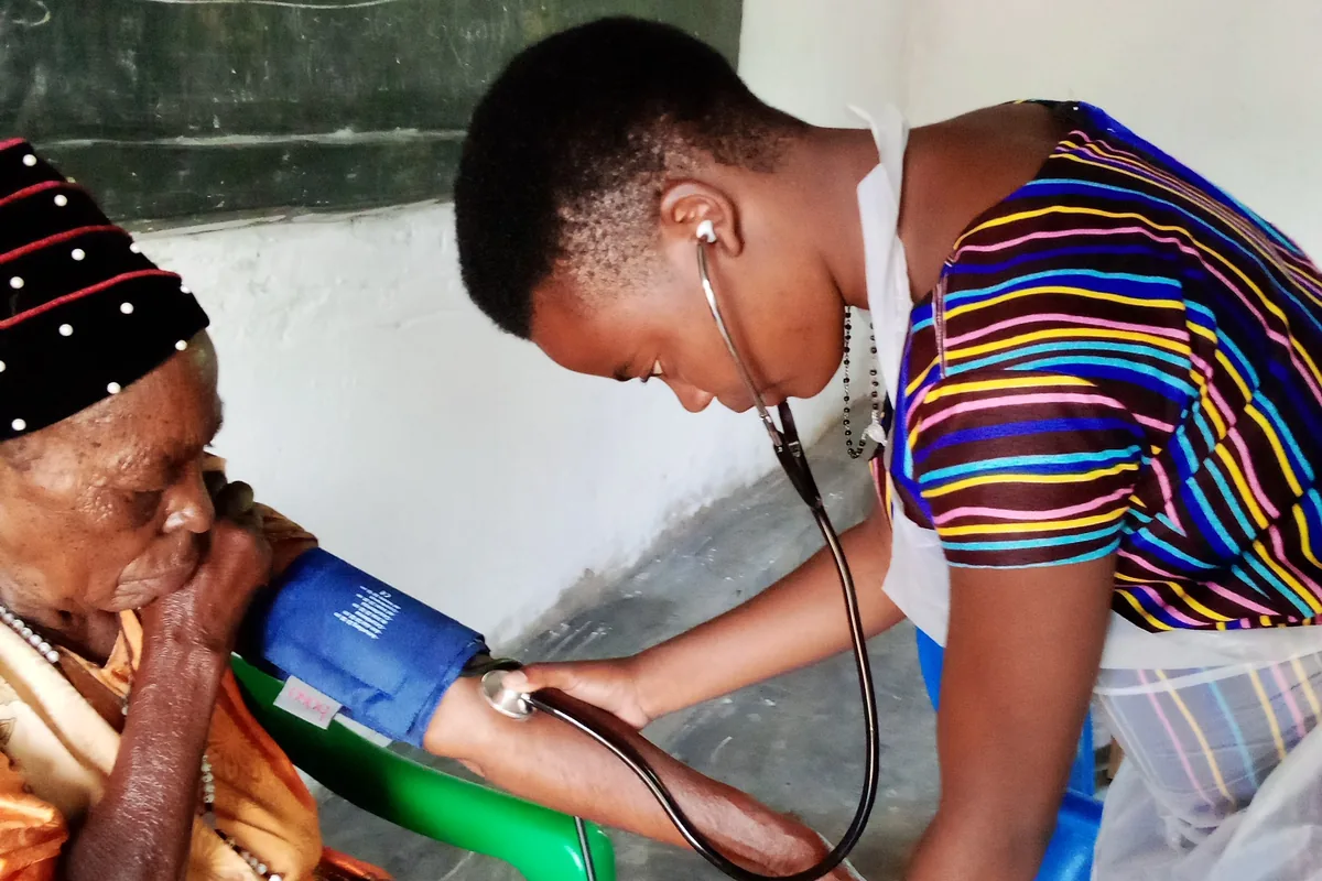 A nurse checking an elderly patient's blood pressure